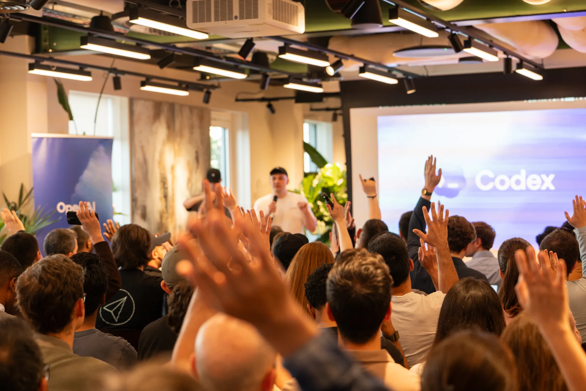 Attendees raising their hands during a Codex community workshop